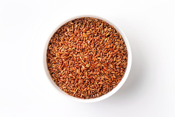 Closeup top view bowl of red raw rice isolated at white background.