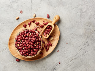 Bowl of fried peanut and scoop with copy space. Top view.