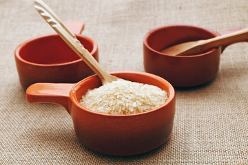 Preparation of rice in a clay pot against the background of a sackcloth