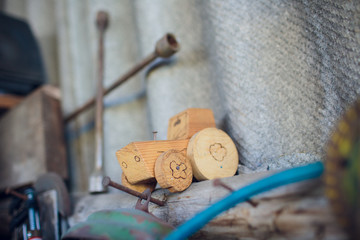 Fototapeta na wymiar Wooden toy tractor with trailer selective focus