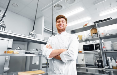 cooking, profession and people concept - happy male chef cook with crossed hands at restaurant...