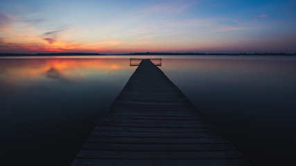 Old empty wooden jetty on lake, during sunrise.