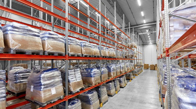 logistic, storage, shipment and industry concept - cargo storing at warehouse shelves
