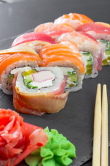 Japanese restaurant, sushi roll on black slate plate.