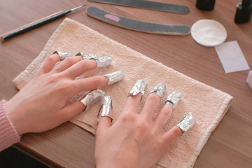 Removing gel Polish from nails. All fingers with foil on both hands. Close-up hand. Front view.