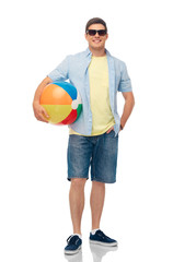 leisure, summer holidays and people concept - smiling young man in sunglasses with beach ball over white background