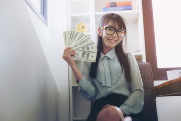 Successful business women are counting money and throwing a dollar at work happily.