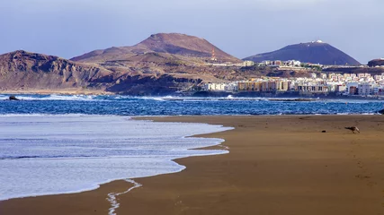 Poster Las-Palmas de Gran Canaria, Spain, on January 10, 2018. The winter sun lights the Playa de Las Canteras beach on the bank of the Atlantic Ocean. beautiful embankment in the distance © Elena Belyaeva