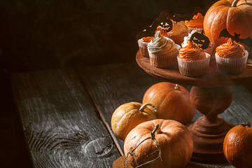 cupcake and pumpkin on a dark background. sweets for the celebration of Halloween.