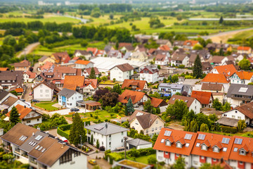 Tilt shift view to small German village from above aerial with tiny hauses