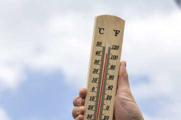 Thermometer displaying high 40 degree hot temperatures in sun summer day. - obrazy, fototapety, plakaty