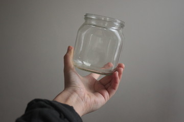 a hand holding an empty glass bottle