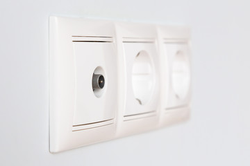 Row of tv and power sockets on a ceramic tile wall