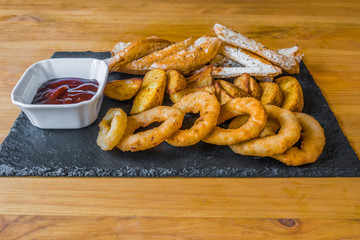 Assorted snacks for beer in the bar. Meat, cheese, onion rings on the grill and deep-fried
