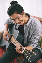 Obraz premium Man enjoying playing guitar