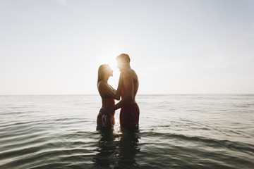 Romantic couple in the sea at sunset