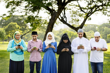 Muslim family holding smartphones