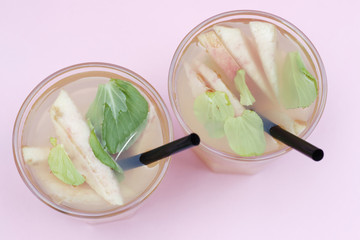 Two glasses with homemade iced tea with pieces of peaches. Summer refreshing drink, top view