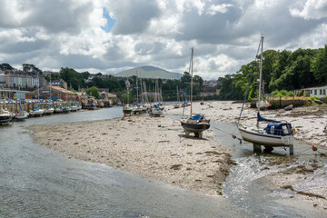 Fototapeta na wymiar Boats at low tide in Afon Seiont river near Caernarfon Castle in summer
