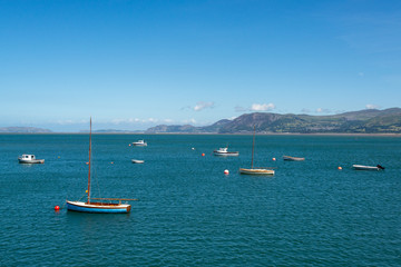 Fototapeta na wymiar Boats in the Menai Strait and Snowdonia in the background on sunny day in summer - 1