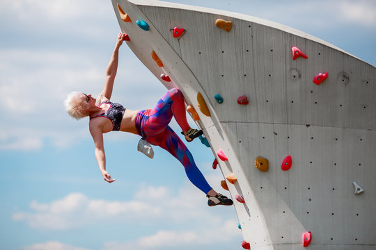 Photo of sportive girl on workout on climbing wall