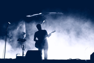 Guitarist silhouette on the stage - obrazy, fototapety, plakaty