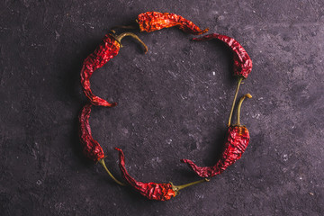 Frame for text from dried, red, hot pepper on a black background. Spice. Copy space