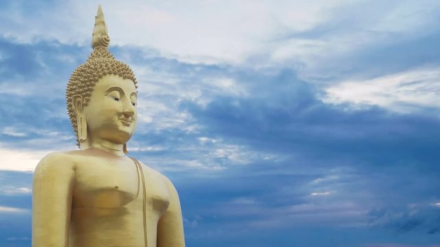 big great powerful Buddha statue in gold color with beautiful time lapse of sky with cloudy at sunset or sunrise time at background. Buddha image for Buddhists