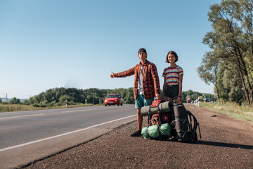 Hitchhiking couple. Backpackers on road