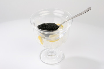 Caviar with spoon and lemon isolated on white