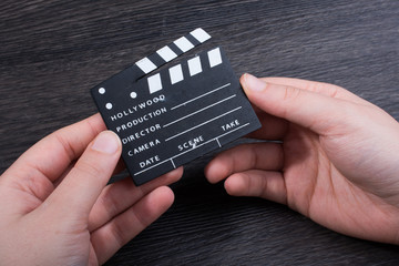 Hand holding a little movie  clapper in hand