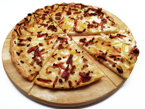 Flammkuchen auf Holzbrett aus dem Elsass freigestgellt auf wei&szlig;em Hintergrund