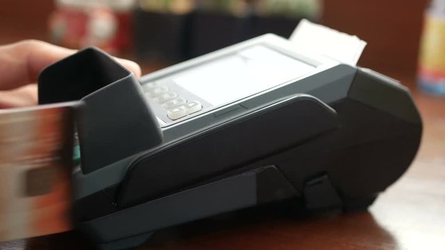 4K footage. man holding credit card in hand , swipe card at credit card terminal reader machine and use finger press password for security for purchase or shopping at shop 