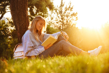 Portrait of a positive young girl sitting on a grass