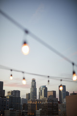 View Of Los Angeles Skyline At Sunset  With String Of Lights In Foreground
