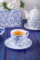 Cup of green tea and teapotand on a blue background. Free space