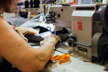 Woman sewing a piece of leather