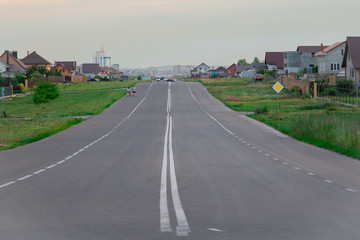 Fototapeta premium Sidewalk and street.New English Property.Asphalt road in a beautiful modern area. A wide road near the house. Way home. Highway to the city