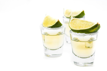 Mexican Gold tequila with lime and salt isolated on white background. Copyspace