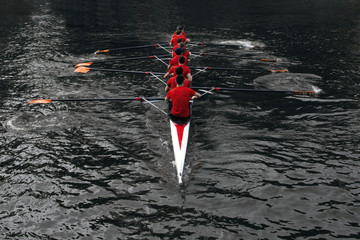 rowers rowing in the dark water. The concept of team sports