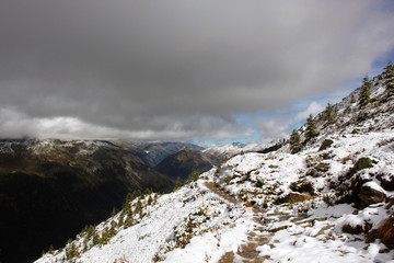 The top of the snow-covered mountain between the clouds.