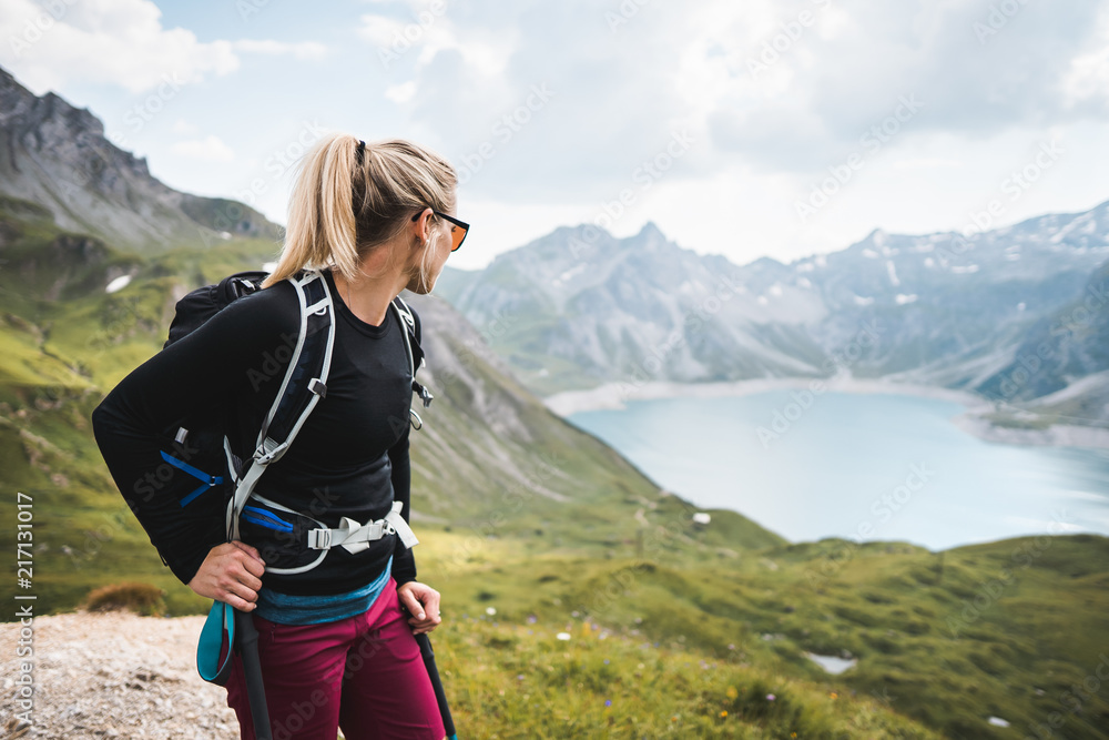 Wall mural adventurous sportive girl hiking at a lake in beautiful alpine mountains