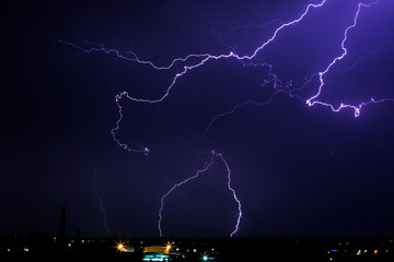 Lightning storm over city in purple light