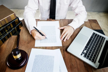 lawyer judge reading documents at desk in courtroom working on wooden desk background. gavel ...