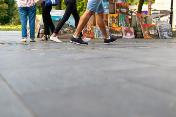 People walking past art seller on a market