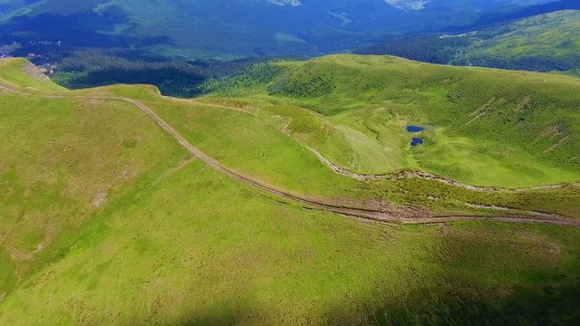 Aerial shot of a long range with a ground lane in the Carpathians in summer
