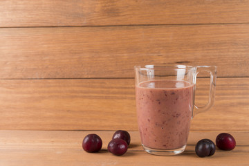 Cherry smoothie on wooden background.