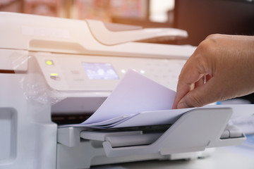 Business Documents concept : Businesswoman hands working in process press of paper in laser printer...
