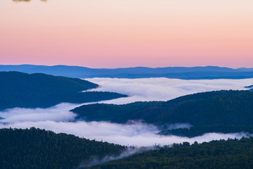Obraz premium Dawn on top of the mountain. The fog at the bottom