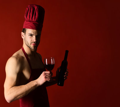 Restaurant. Wine cellar. Red wine. Chef in apron tastes wine. Bearded man holds bottle of wine. Wine making. Italian style. Isolated. Alcohol. Silhouette of sommelier.
